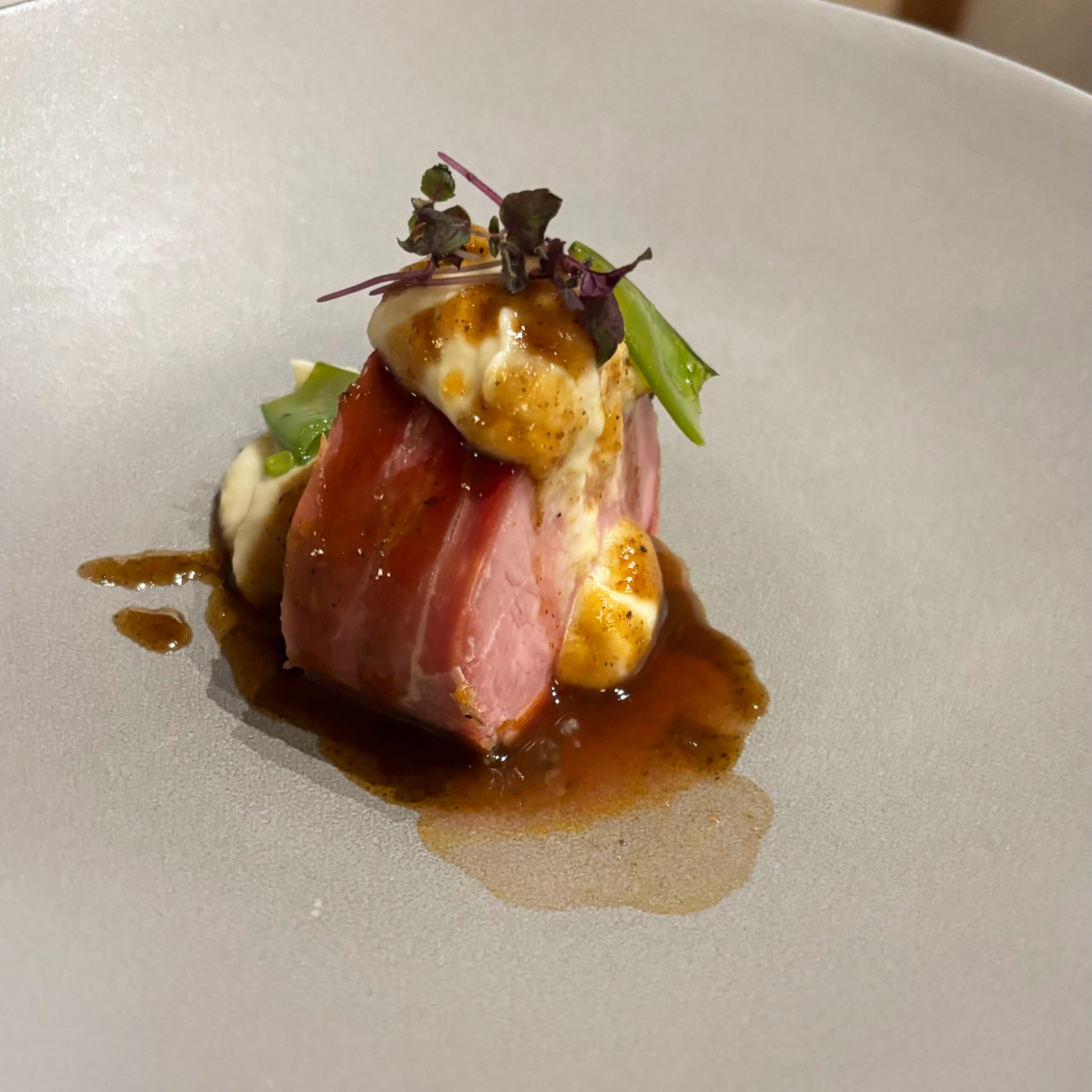 Fein angerichtetes Gericht mit Fleisch, Mais und Kräutern.