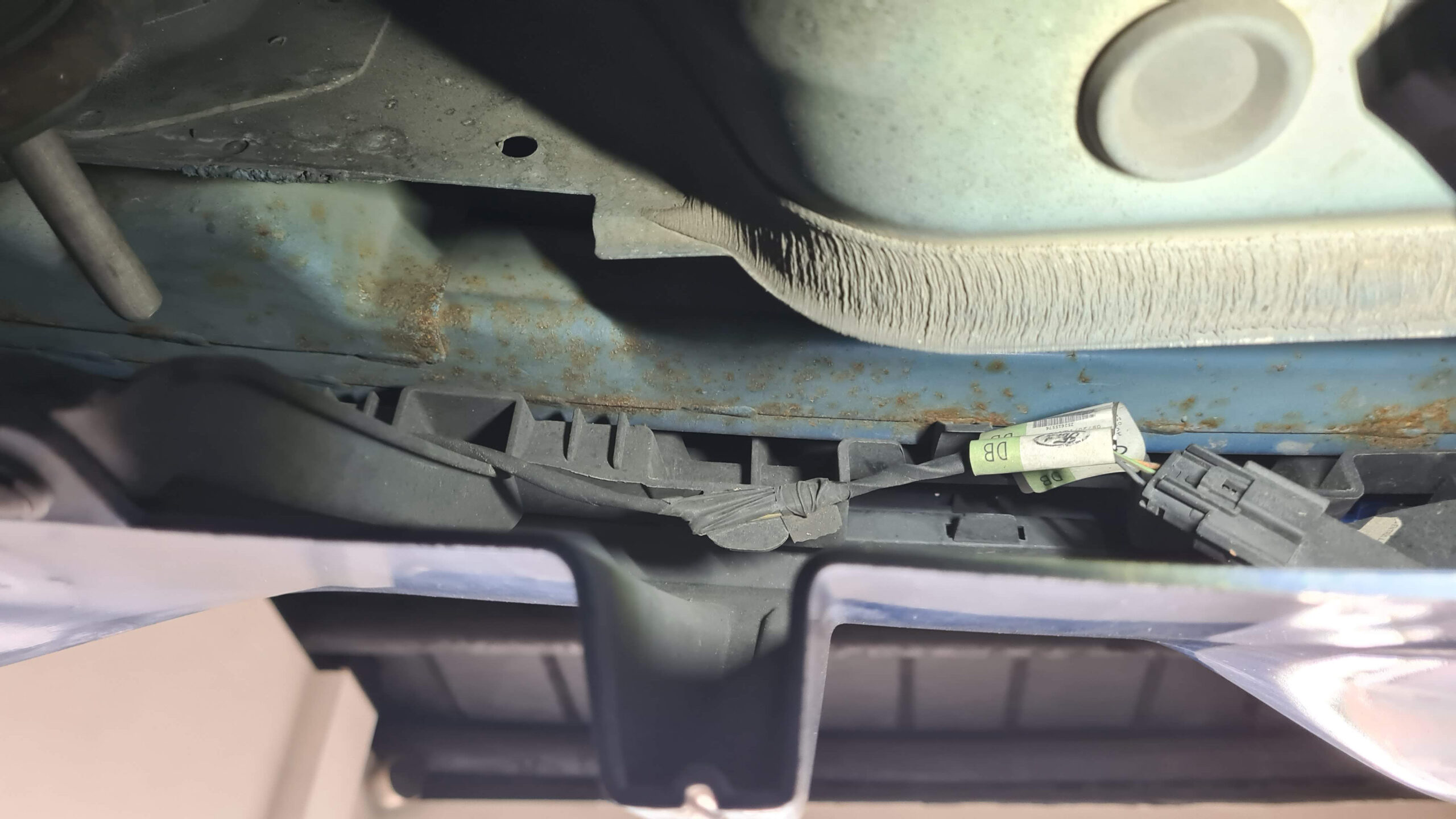 Nahaufnahme eines rostigen Autoteils unter dem Mustang.