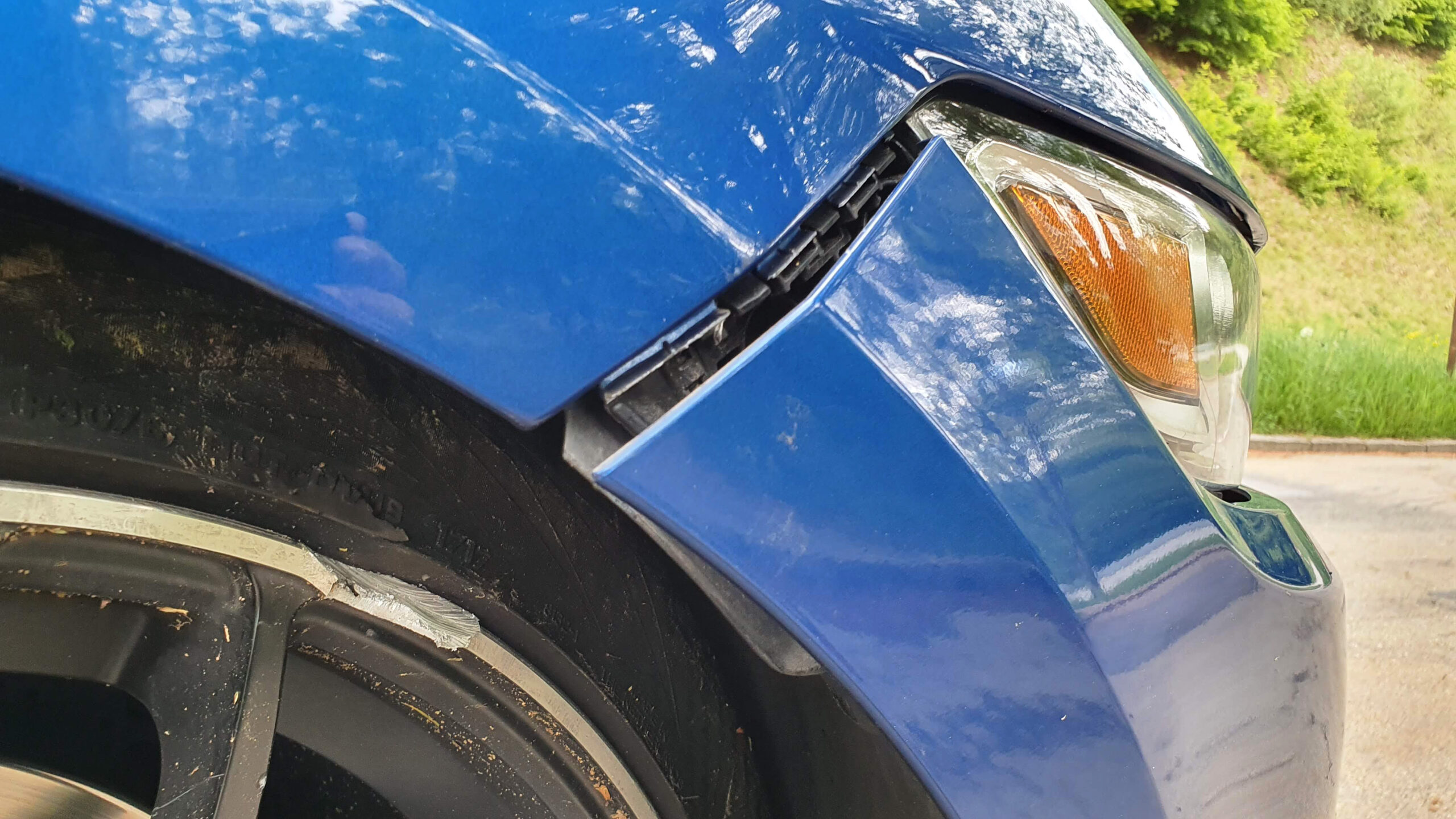 Riss oder Spalt zwischen Stoßfänger und Kotflügel bei einem Ford Mustang nach einem Wildunfall. Auch eine beschädigte Felge ist zu sehen.