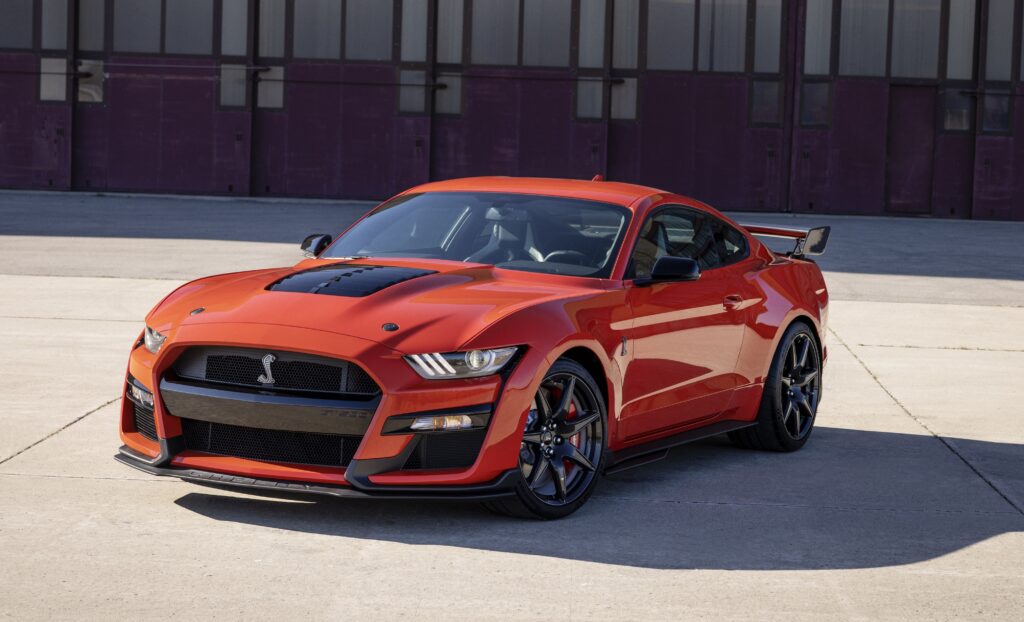 Ein roter Shelby GT500 auf einem Parkplatz vor einem Gebäude