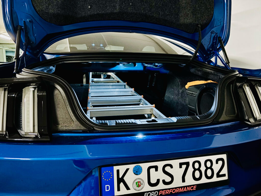 Blick in den Kofferraum des Mustang GT mit umgeklappter Rückbank und einer Leiter im Kofferraum